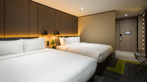 Une chambre d’hôtel avec deux lits, une table de chevet avec des lampes, un miroir et une porte dotée d’un interrupteur.