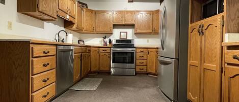 A kitchen with wooden cabinets, stainless steel appliances, and a central island.