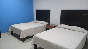 Two single beds with headboards, a wooden nightstand, and a blue wall. - Hotel Tampico Express (Ciudad Madero)