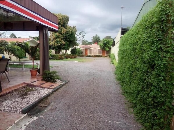 A paved pathway leading to a building with a covered entrance.