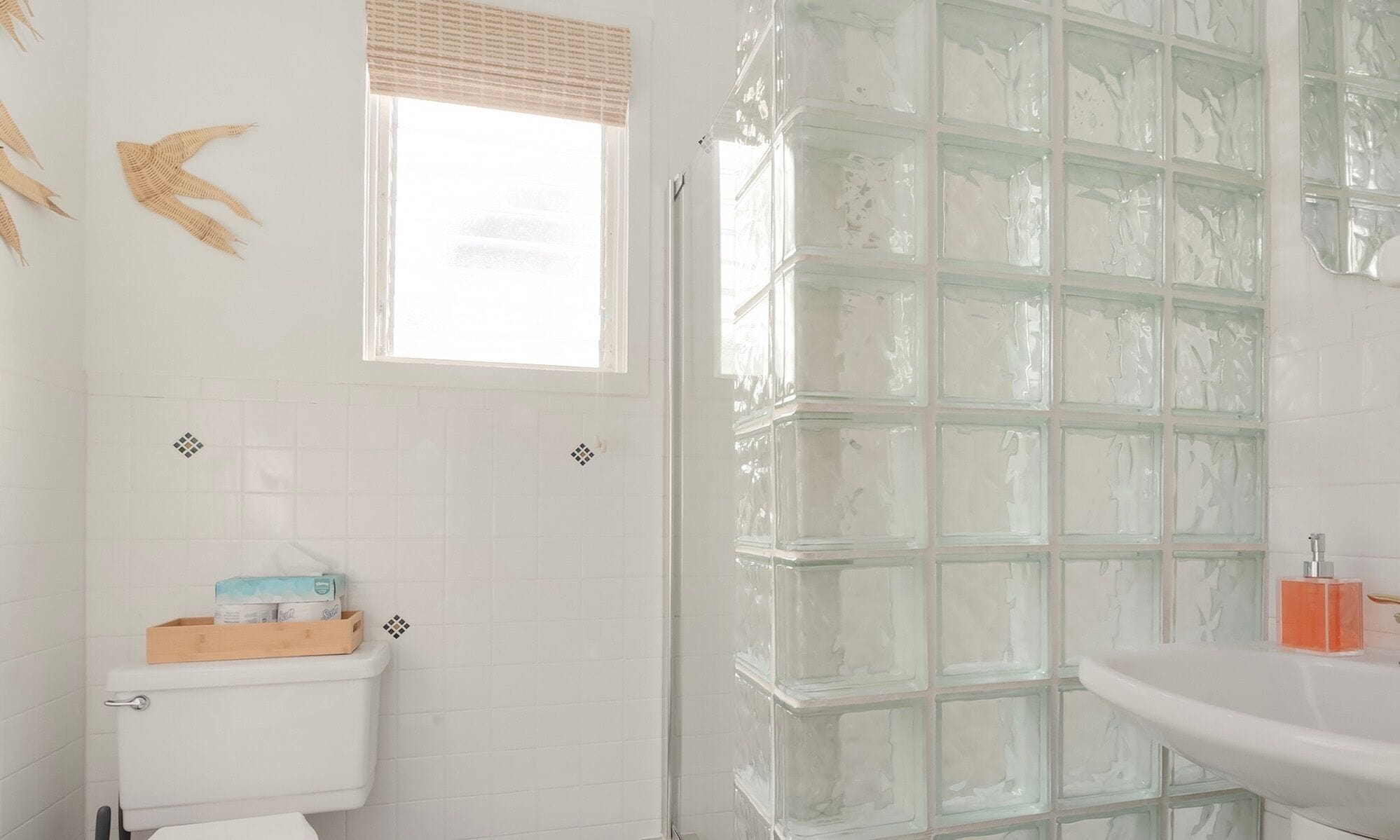 Un bagno con il water, un lavabo e un box doccia in vetro.