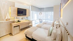 A modern hotel room with a large bed, a desk, a TV, and a balcony with a view. - Hotel Perla Suite Santa Marta (Santa Marta)