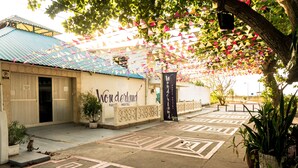 A hostel named 'Wonderland' with a corrugated metal roof, a gated entrance, and a patterned pavement. - Wonderland Hostel By GB Collection (Cartagena)