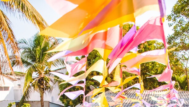 A swimming pool with a person lying on a pink float, surrounded by colorful fabric decorations. - Wonderland Hostel By GB Collection (Cartagena)