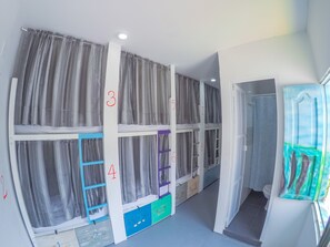 A children's playroom with bunk beds, numbered storage units, and a window with a view.