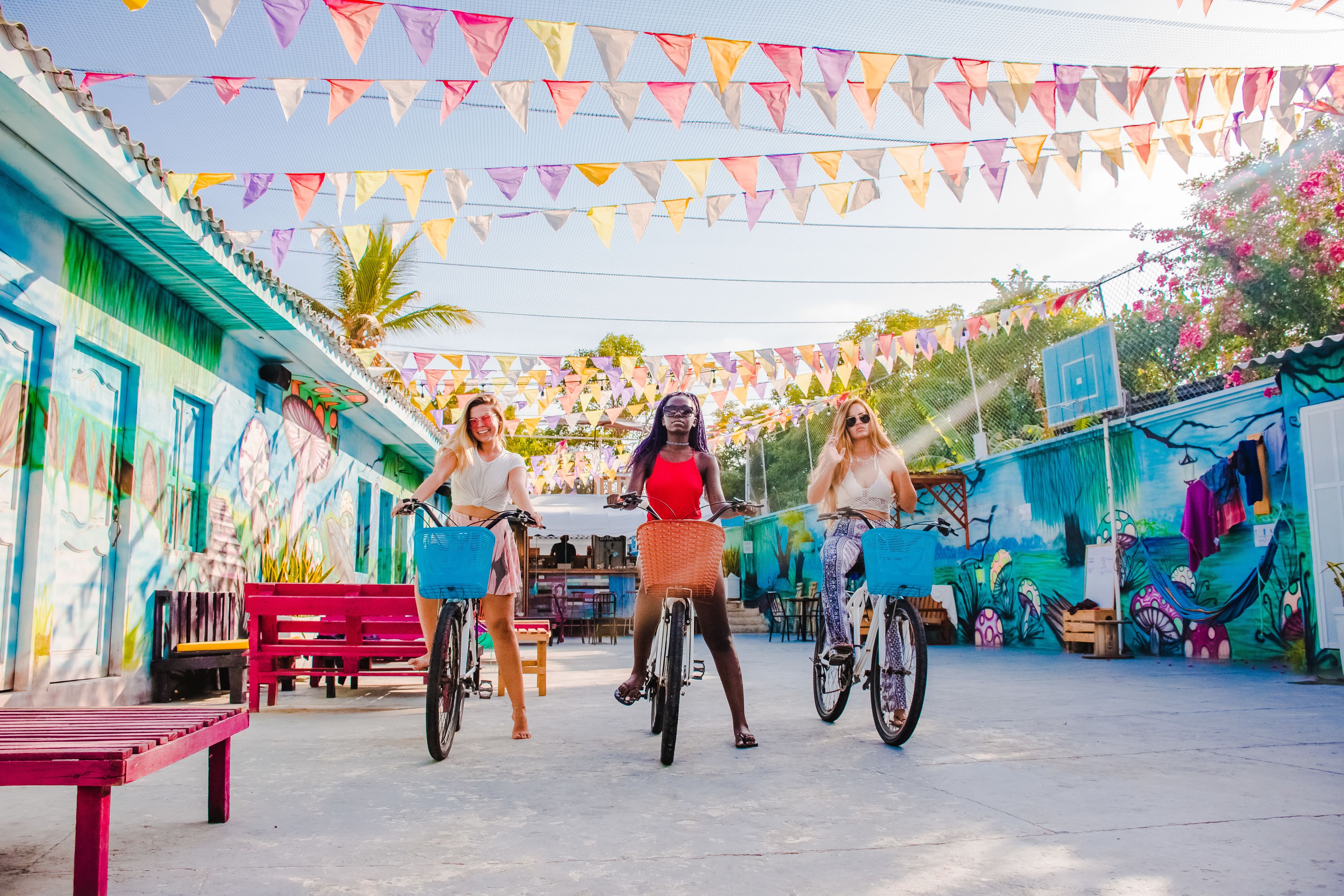 A colorful outdoor area with a mural, a bicycle lane, and a red bench.