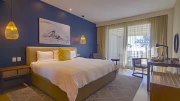 A modern hotel room with a large bed, a desk, and a view of the outdoors.