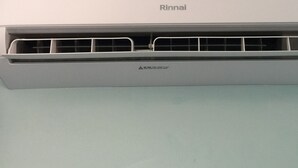 A white air conditioning unit with the brand name 'Rinnai' on the top. - Caversham B&B (Beechboro)