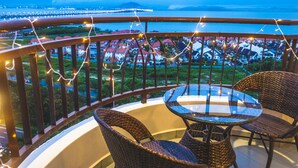 A balcony with wicker chairs and a glass table, overlooking a coastal town with houses and a bridge. - Panoramic 180 Cozy Suite by D Imperio Homestay (George Town)