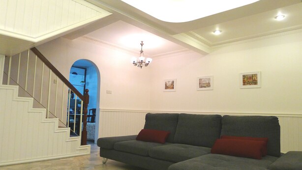 A living room with a grey sectional sofa, a staircase, and a chandelier. - Bukit Tinggi Klang - Cozy Home (Klang)