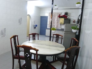 Un comedor con una mesa redonda y cuatro sillas de madera.