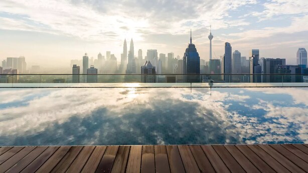 A city skyline reflected in a glass surface with a wooden deck in the foreground. - Wong's Homestay at Regalia Residence (Kuala Lumpur)