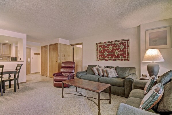 Relax in this inviting living space with a comfortable armchair, plush sofa, and warm rug.