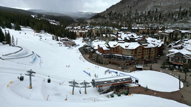 A ski resort with multiple lodges, a ski lift, and a snow-covered landscape.