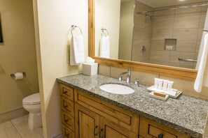 A bathroom with a granite countertop, a sink, a mirror, a toilet, and a shower area. - Newly updated in Canyons Village Next to Slopes by RedAwning (Park City)