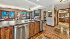 A modern kitchen with a large island, stainless steel appliances, wooden cabinets, and a view to the outside. - 2 Br 2 Ba Luxury Condo. Walk to South Lake Tahoe! (South Lake Tahoe)