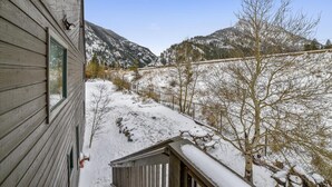 A wooden cabin with a window overlooking a snowy landscape and mountains. - Forest Park F (Frisco)