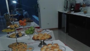 Una mesa de buffet con diversos alimentos y cestas de pan.