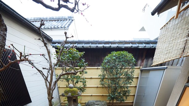 A traditional Japanese garden with a stone lantern, rock formations, and a small water feature. - Miyazakiya (Kyoto)