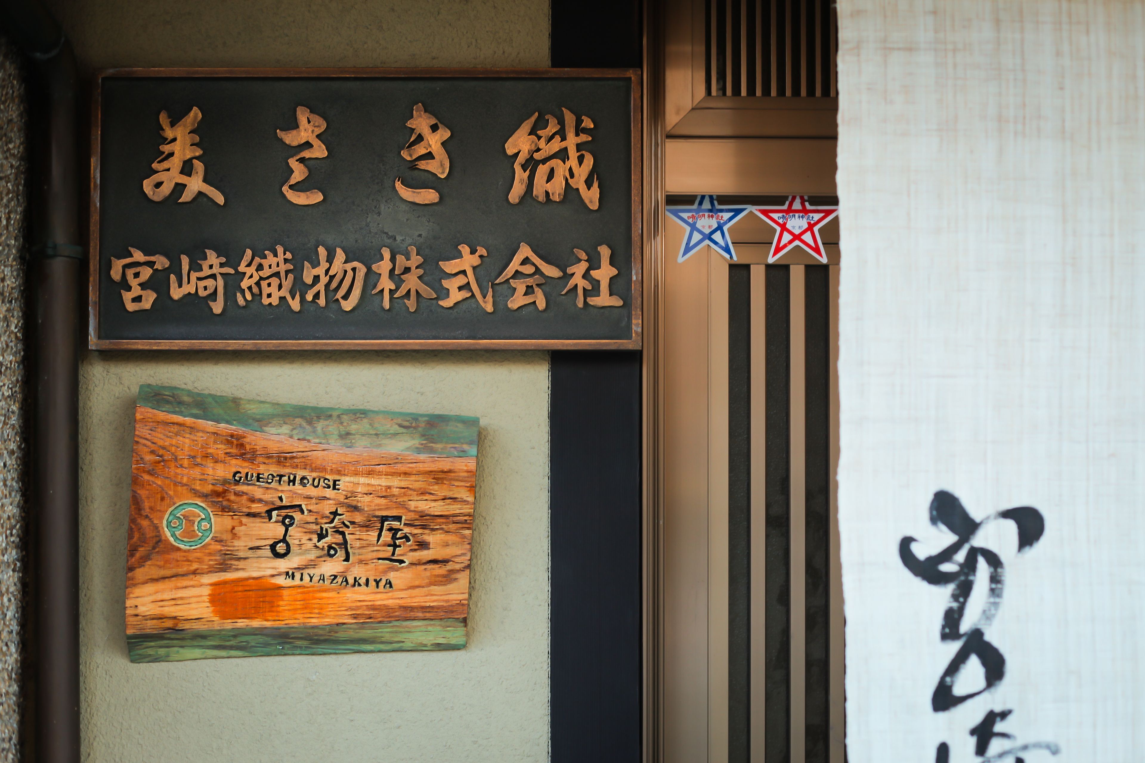 A sign with Japanese characters and a wooden plaque below it.