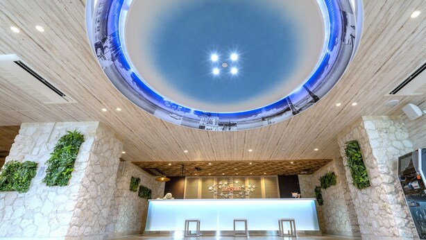 A reception area with a circular skylight, stone walls, and a wooden ceiling. - La'gent Hotel Okinawa Chatan - Hostel (Chatan)