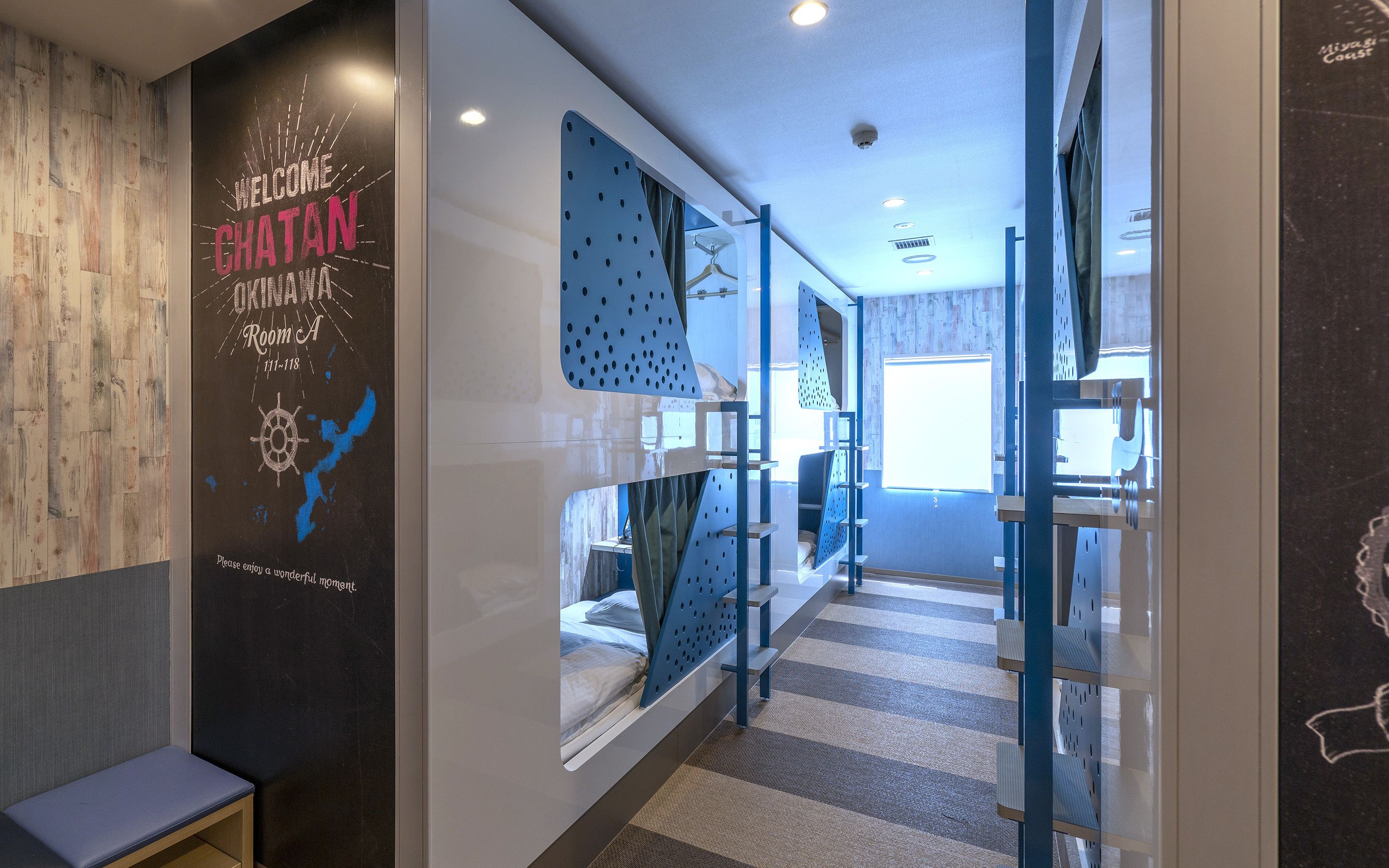 A modern hotel corridor with a wooden wall, a welcome sign, and a check-in counter.