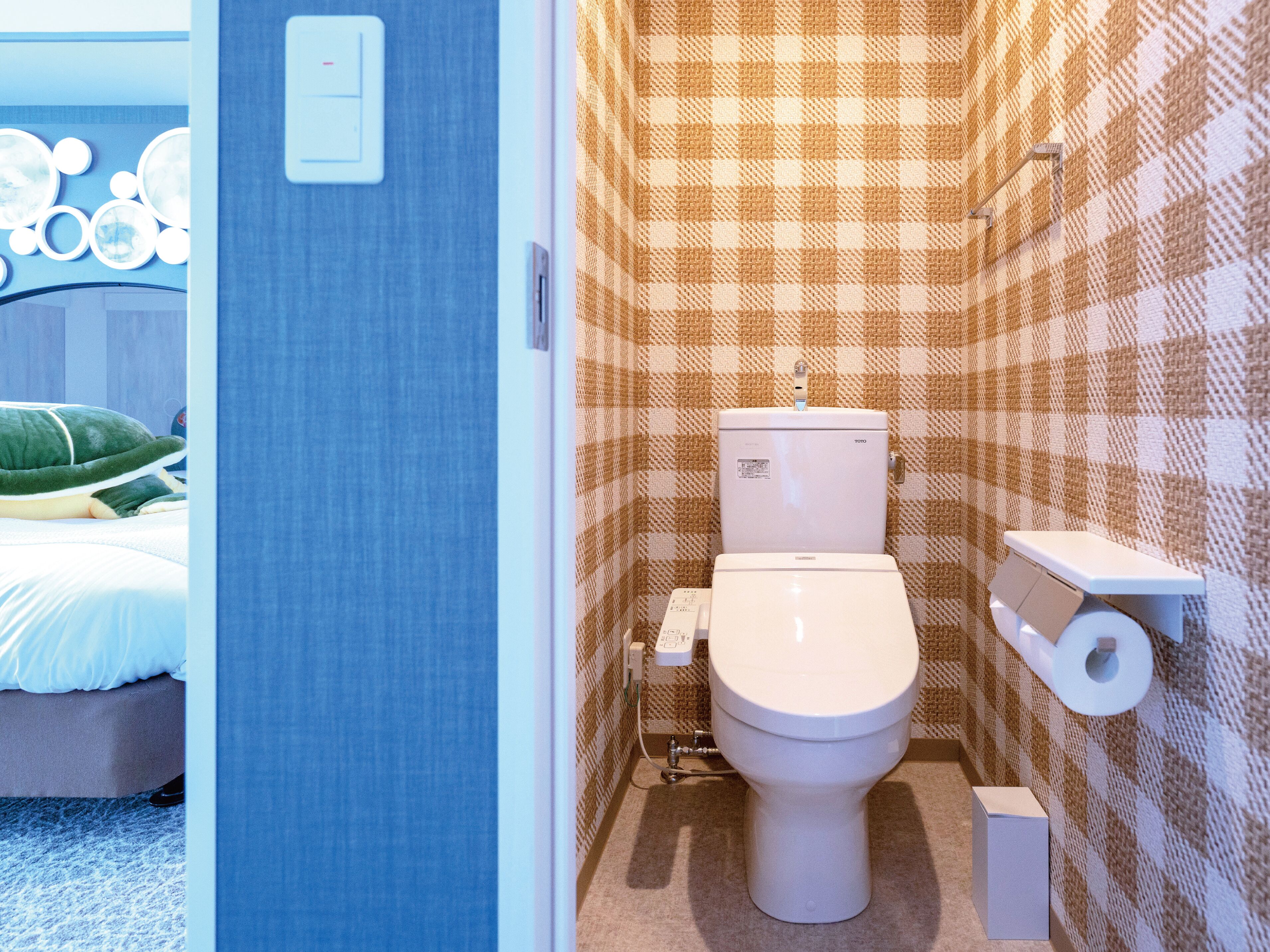 Ein kleines Badezimmer mit Toilette, Toilettenpapierhalter und einem Handtuchhalter an der Wand.
