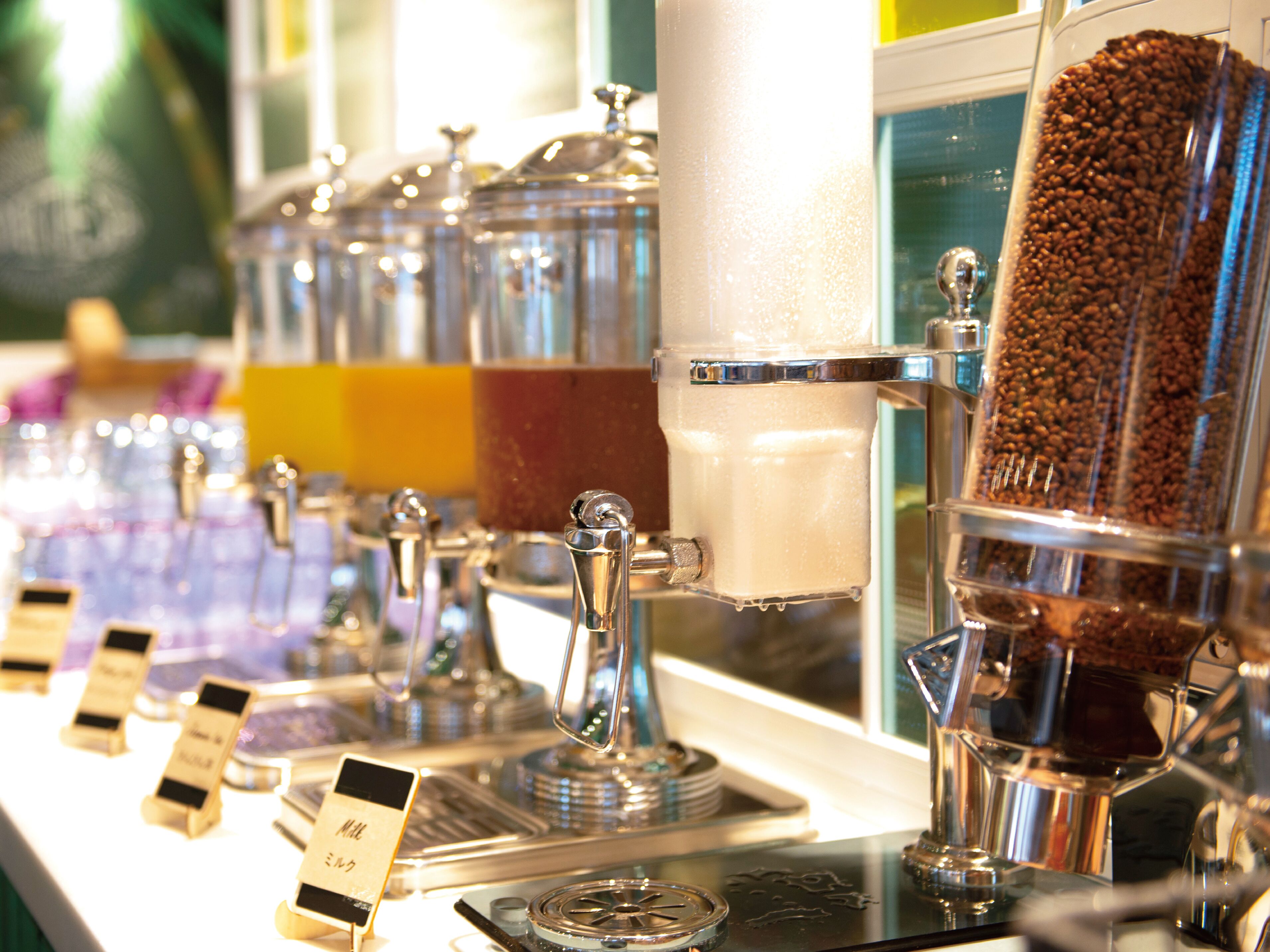 Una máquina de café con varios dispensadores y un depósito para granos de café.