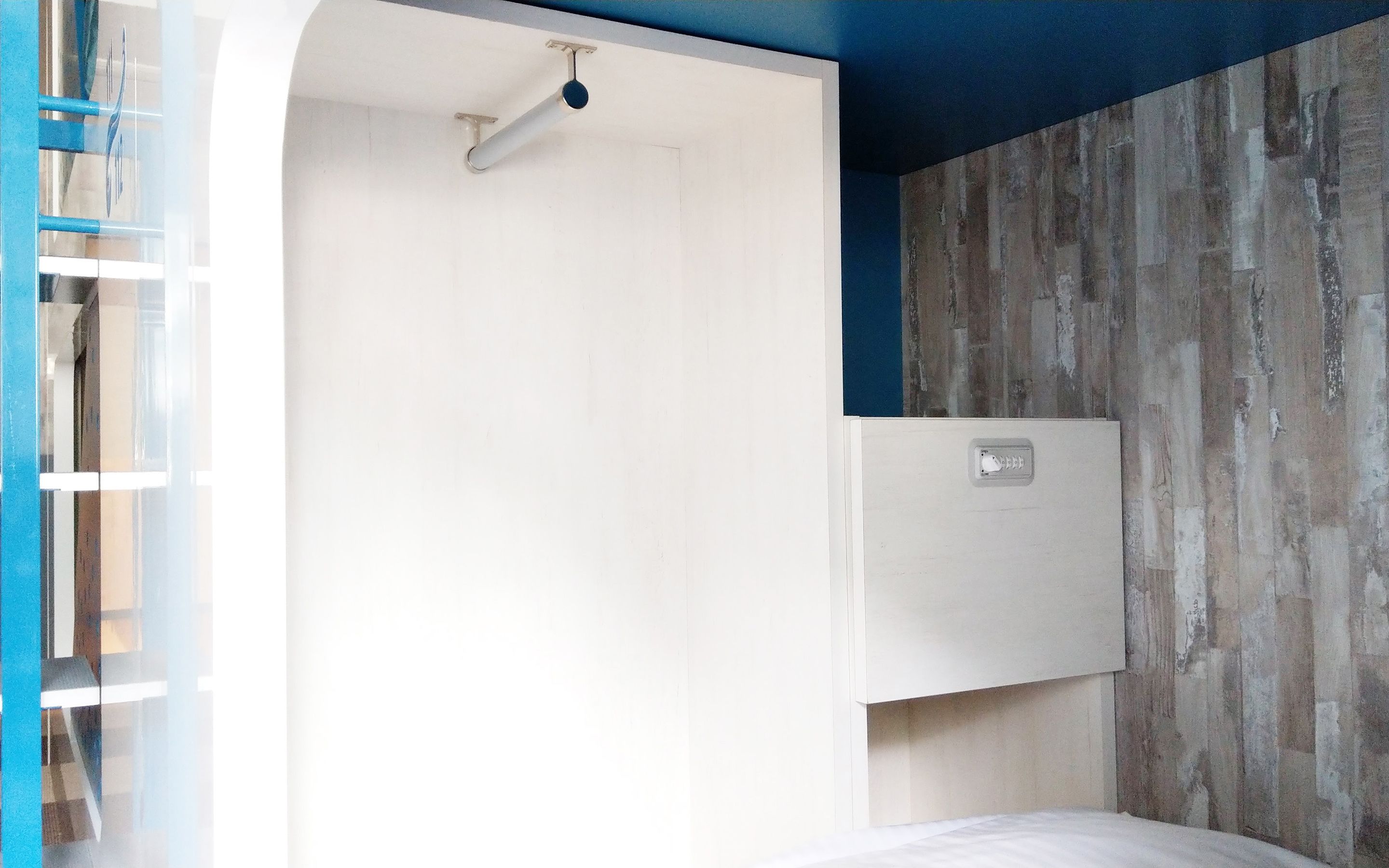 Ein Schlafzimmer mit weißer Tür, einer Holzvertäfelung und einem Bett.