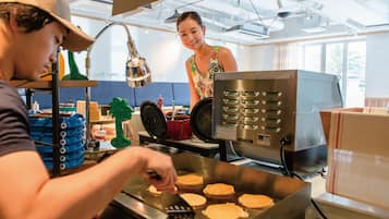 A kitchen with a griddle, cooking utensils, and a person preparing food.