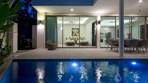 Uma casa moderna com piscina, área de jantar e quarto com cama grande e ventilador de teto.