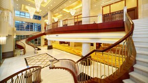 A grand hotel lobby with a spacious atrium, a grand staircase, and ornate chandeliers. - C&D Hotel Putian (Putian)