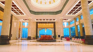 A spacious lobby with a central fountain, large windows, and a high ceiling with a circular skylight. - C&D Hotel Putian (Putian)