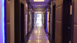 A long, well-lit corridor with reflective flooring and doors on both sides. - Moments (Lucknow)