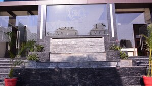 A modern building facade with a large glass window displaying the logo and the words "MOTEL STAY FOREVER". - Moments (Lucknow)