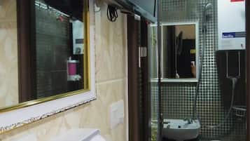 Um banheiro com espelho, secador de cabelo, pia e vaso sanitário.