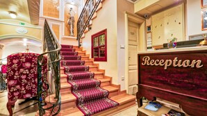 A grand staircase with red carpeted steps leading to a reception area. - Arbia Dorka Heritage Palace (Varazdin)