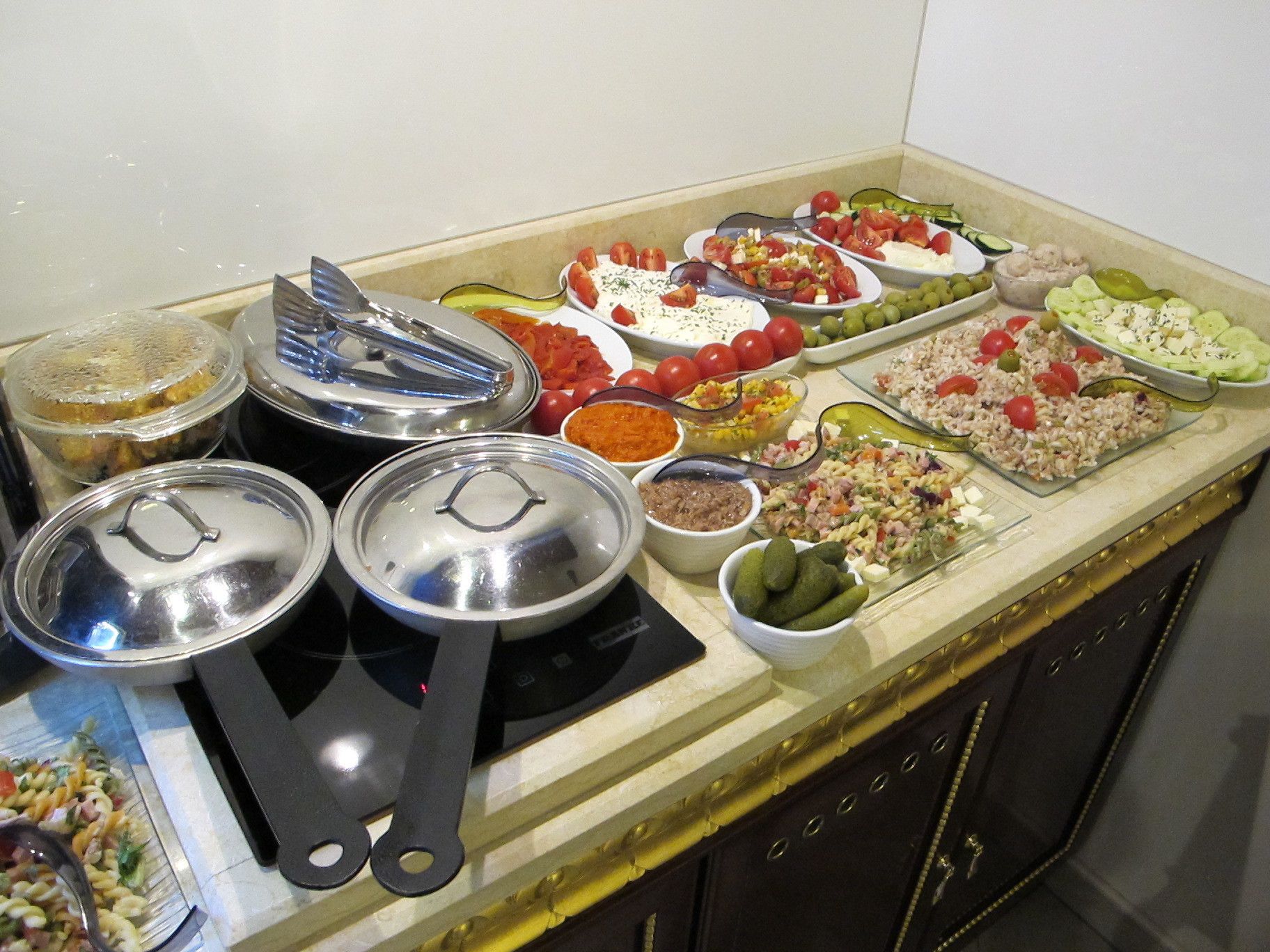 A buffet with various dishes and condiments.