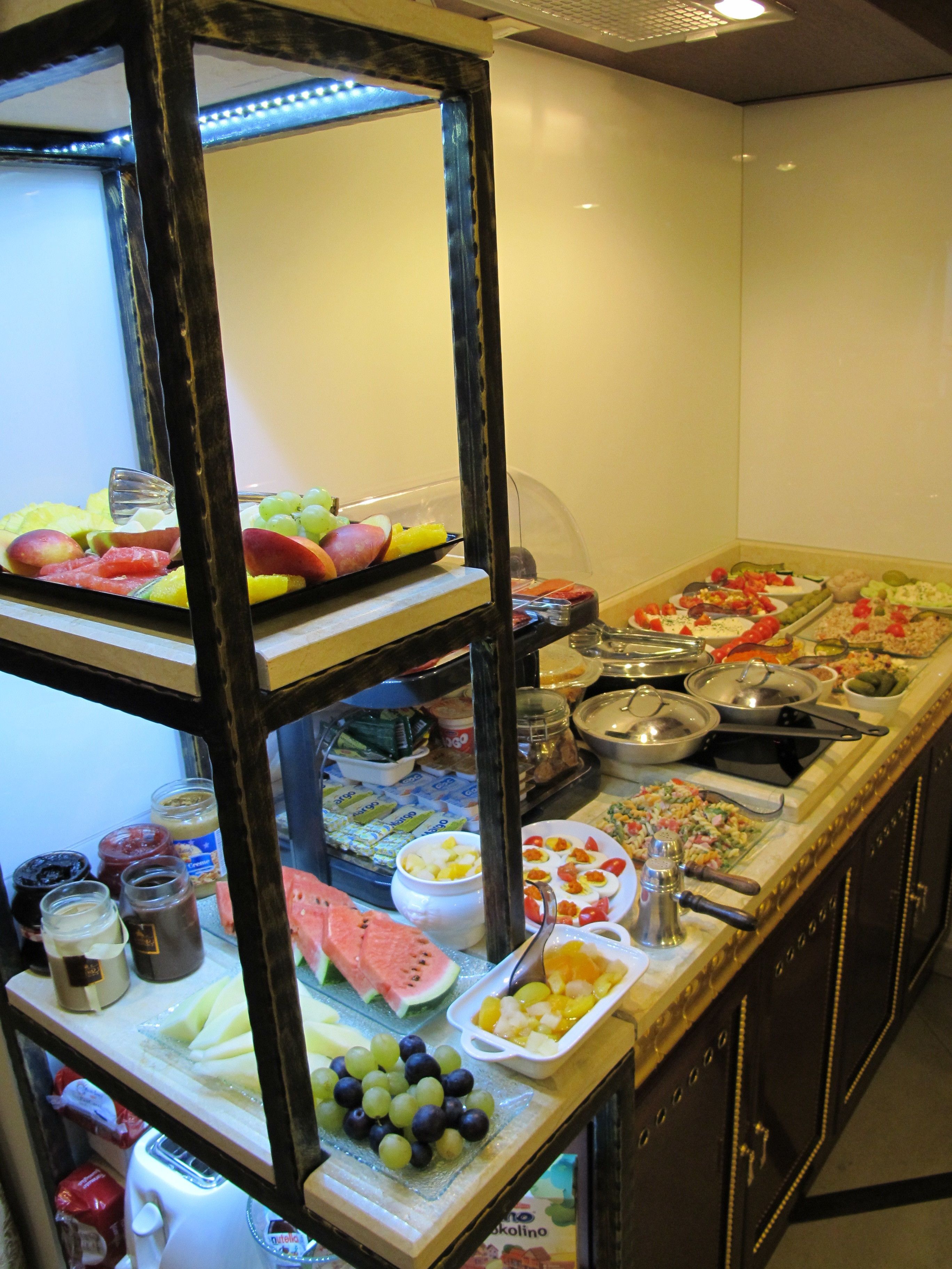 A buffet with various food items including fruits, vegetables, and prepared dishes.