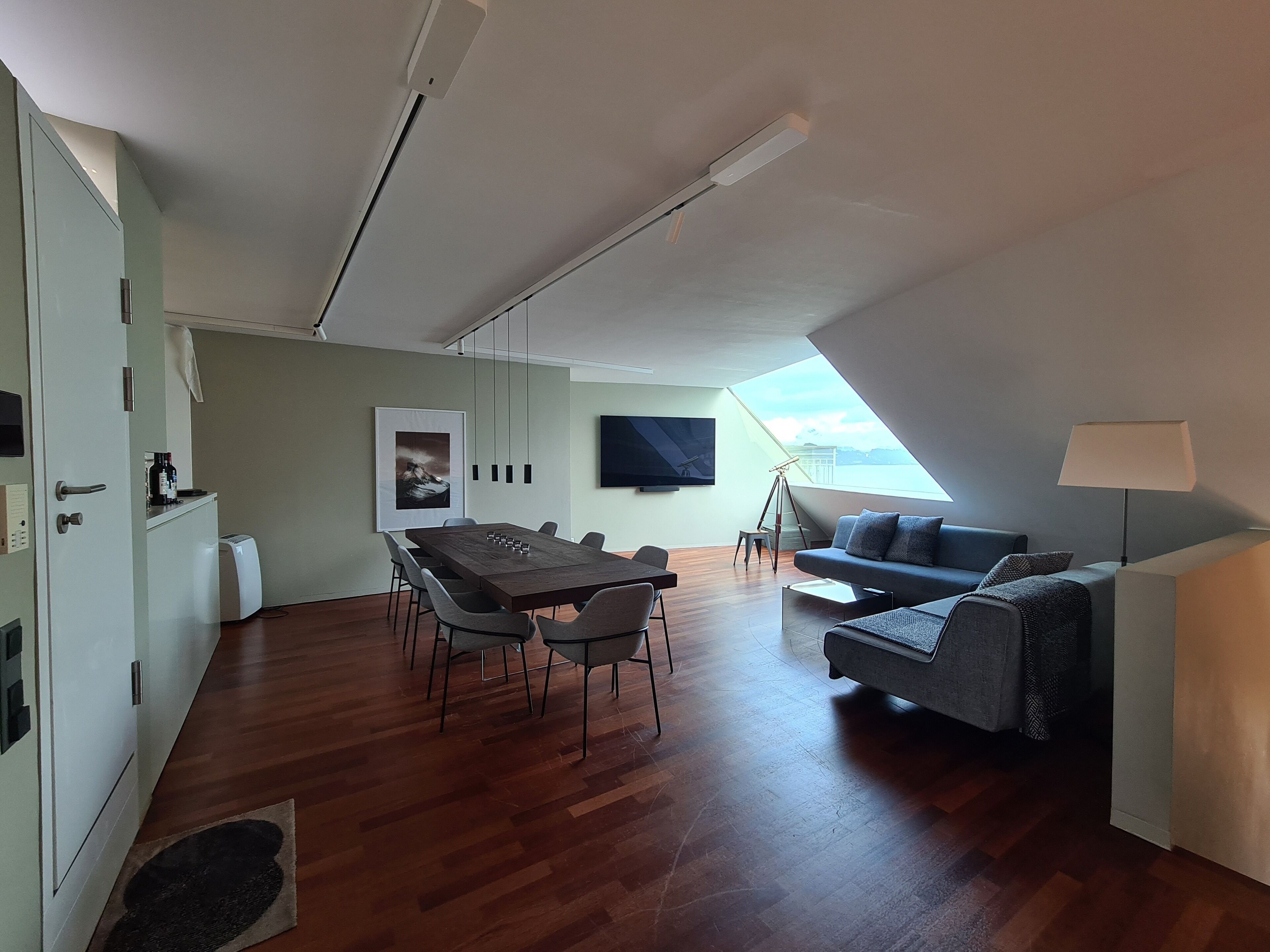 Un moderno apartamento tipo loft con comedor, sofá y telescopio.