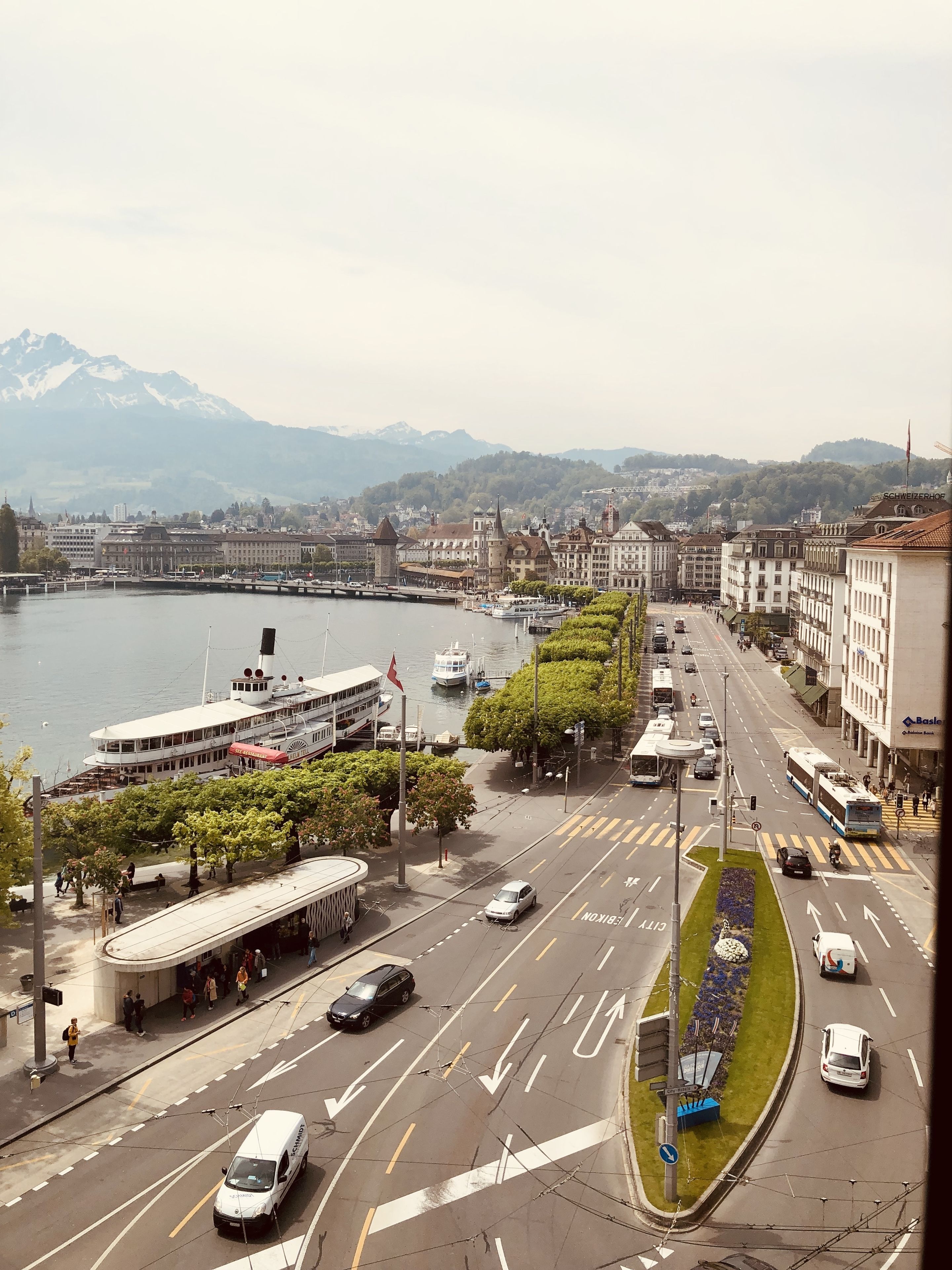 A cityscape with a river, buildings, and a tram line.