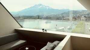 A modern room with a large skylight overlooking a cityscape and a river. - Lucerne Lake View Apartments (Lucerne)