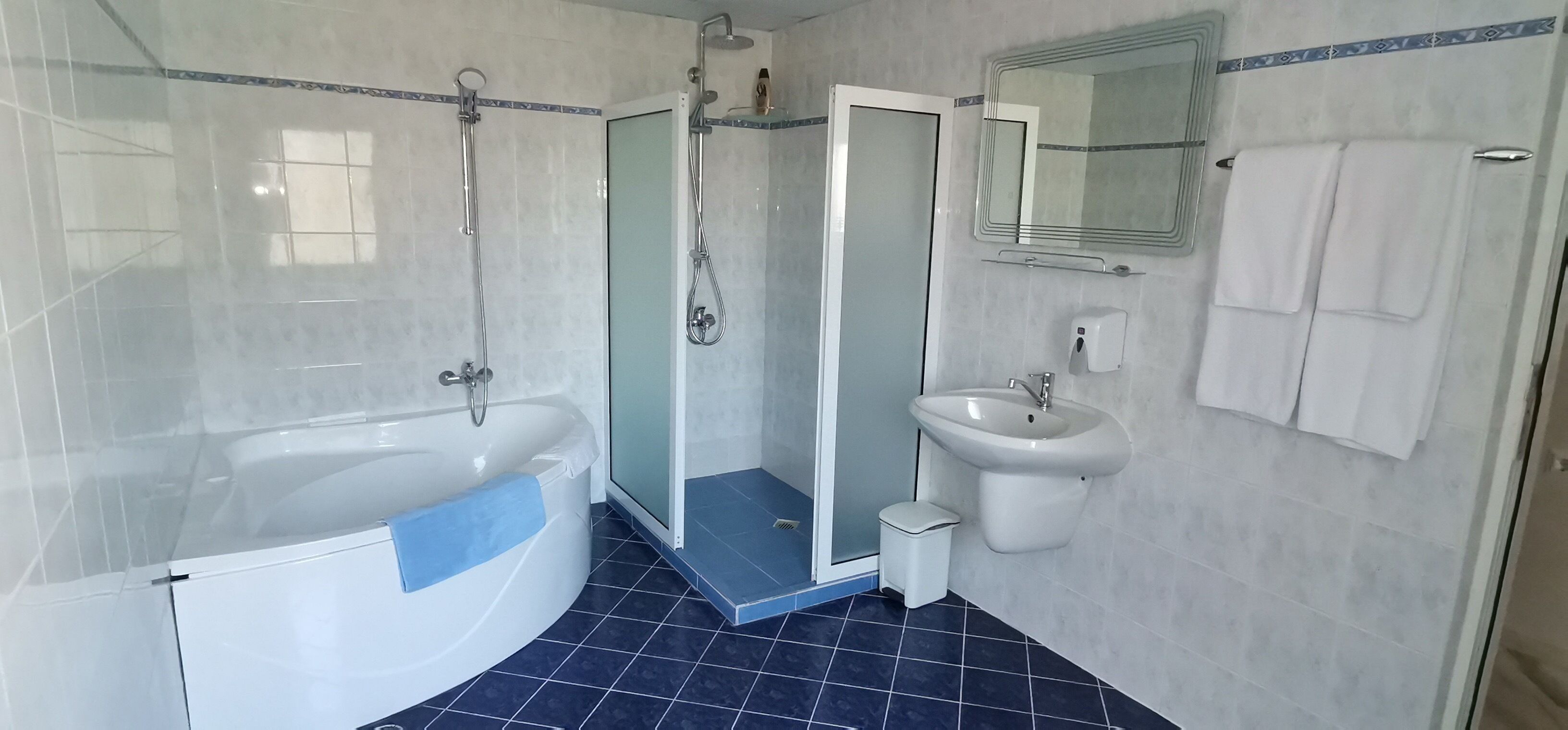 A bathroom with a bathtub, shower, and sink.
