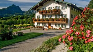 A two-story building with balconies, a gravel driveway, and a mountainous backdrop. - Leitnerhof (Bad Reichenhall)