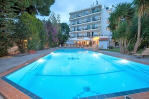 Una piscina al aire libre, sombrillas, tumbonas