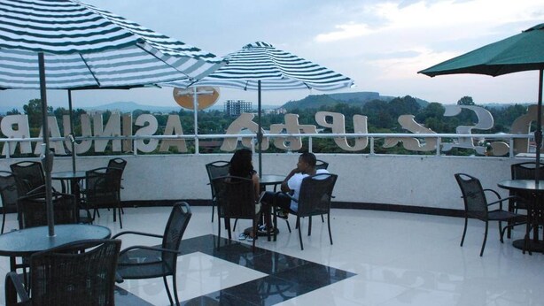Terraza en la azotea con mobiliario exterior, sombrillas y vistas del paisaje.