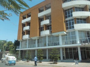 A multi-story building with a modern architectural design, featuring balconies and large windows. - Asinuara Hotel (Bahir Dar)