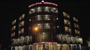 Un hotel de varios pisos con señalización iluminada y fachada de vidrio.