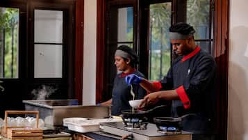 Cozinha com fogão, panelas e alguém cozinhando.