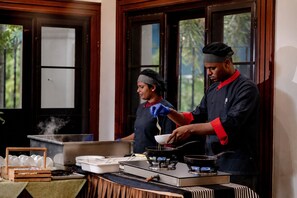 Una cocina con estufa, ollas y una persona cocinando.
